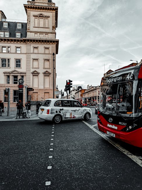 A city street scene showing a red and black double-decker bus stopped at a pedestrian crossing, with the route number 46 and destination Paddington displayed on the front. To the left, a white taxi wi